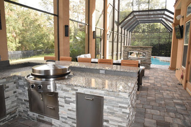 Outdoor kitchen deck - traditional backyard outdoor kitchen deck idea in Jacksonville with a roof extension