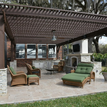 Outdoor kitchen wit pergola and fireplace.
