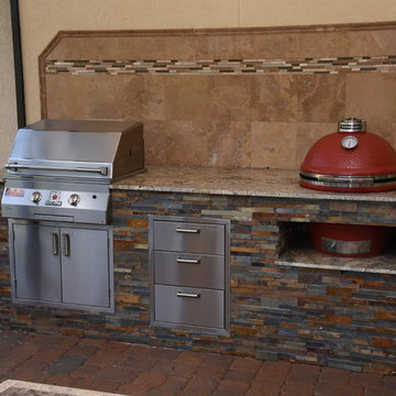 Outdoor kitchen with Kamado Joe, Solaire gas grill, fire pit, and seating wall