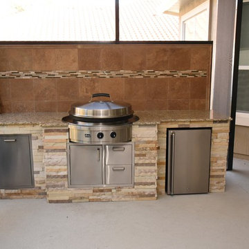 Outdoor kitchen with privacy wall and Evo flat top grill.