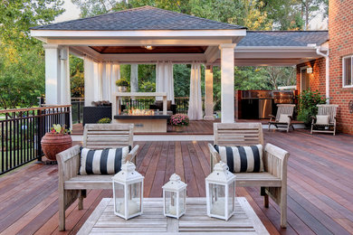 Cette photo montre une grande terrasse latérale craftsman avec un foyer extérieur et une extension de toiture.