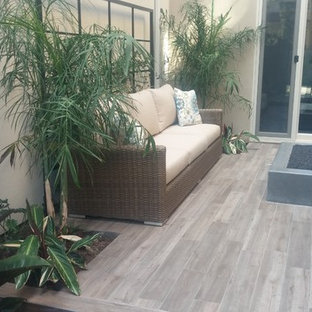 Small trendy courtyard deck photo in Orange County with a fire pit