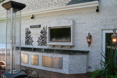 Diseño de terraza contemporánea grande sin cubierta en patio trasero con cocina exterior