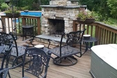 Example of a mid-sized transitional backyard deck design in New York with a fireplace and no cover