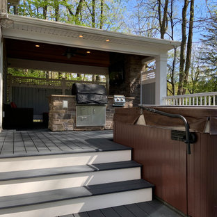 Example of a mid-sized eclectic backyard deck design in New York with a fireplace and a roof extension