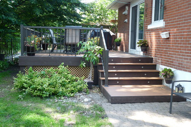 Example of a mid-sized classic backyard deck design in Montreal with no cover