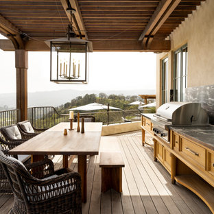Example of a classic outdoor kitchen deck design in San Francisco with a roof extension