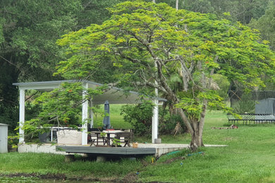 サンシャインコーストにある中くらいなカントリー風のおしゃれな裏庭のデッキ (パーゴラ) の写真
