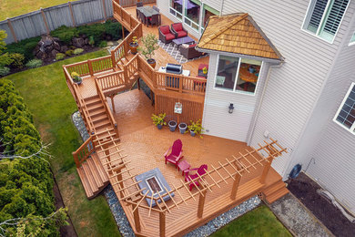 Example of a large arts and crafts backyard deck design in Seattle with no cover