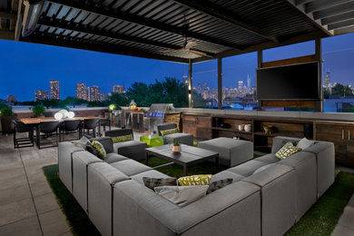 Inspiration for a huge contemporary rooftop outdoor kitchen deck remodel in Chicago with an awning