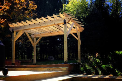 Deck - traditional backyard deck idea in Grand Rapids with a pergola