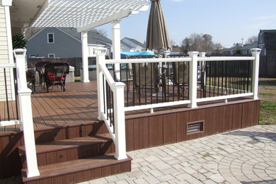 Deck - large traditional backyard deck idea in Other with a pergola