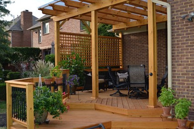 Example of a mid-sized classic backyard deck design in Other with a pergola
