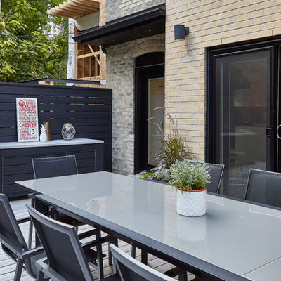 Large minimalist backyard outdoor kitchen deck photo in Toronto with a pergola