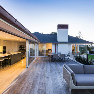 Example of a large classic rooftop deck design in Auckland with a fireplace and no cover