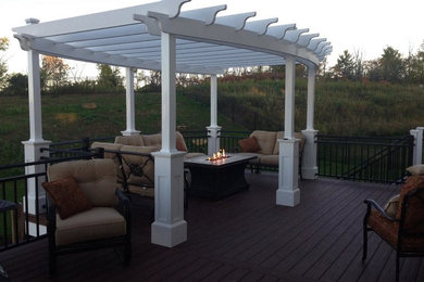 This is an example of a large back terrace in Minneapolis with a pergola.