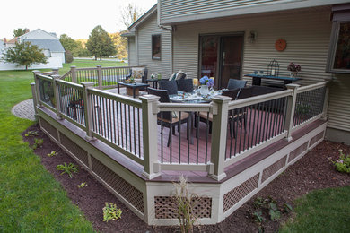 Example of a large arts and crafts backyard deck design in Boston with a fire pit and no cover