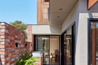 Contemporary side terrace in Melbourne with a roof extension.