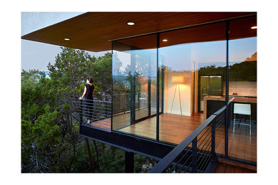 Inspiration for a small modern side yard deck remodel in Austin with a roof extension