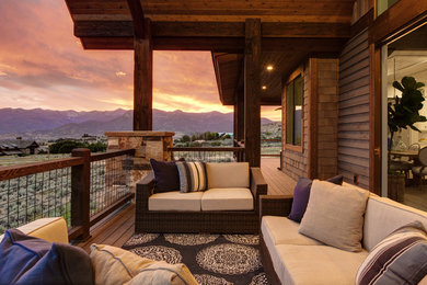 Example of a large mountain style side yard deck design in Salt Lake City with a roof extension and a fire pit