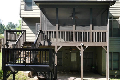 Example of a mid-sized backyard deck design in Atlanta with a roof extension