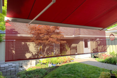 Example of a mid-sized classic backyard deck design in Vancouver with an awning