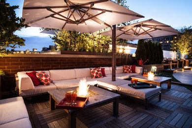 Large trendy rooftop deck photo in Chicago with a fire pit and an awning