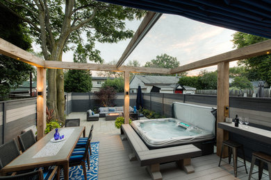 Example of a mid-sized minimalist backyard deck design in Toronto with an awning