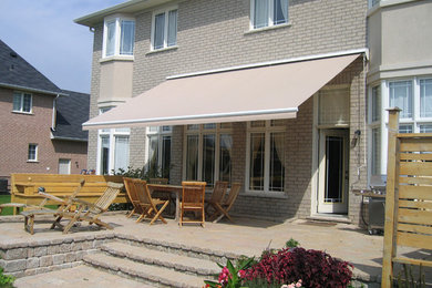 Mid-sized elegant backyard outdoor kitchen deck photo in Calgary with an awning