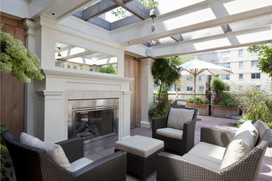 Deck - large traditional rooftop deck idea in New York with a fire pit and a pergola