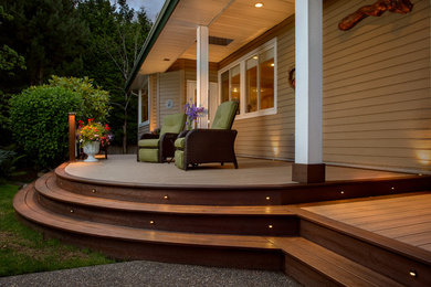 Example of a mid-sized transitional backyard deck design in Vancouver with a roof extension
