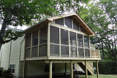 Inspiration pour une terrasse arrière traditionnelle de taille moyenne avec une extension de toiture.
