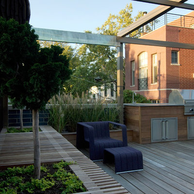 Example of a large minimalist rooftop outdoor kitchen deck design in Chicago with an awning
