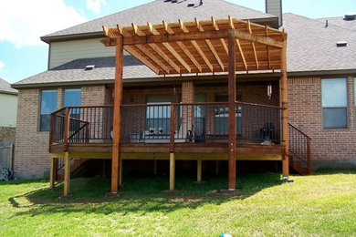 Foto de terraza de estilo americano de tamaño medio en patio trasero con pérgola
