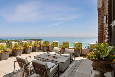 Inspiration for a large transitional rooftop deck remodel in Chicago with a fire pit