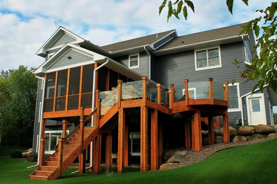Example of a mid-sized minimalist backyard deck design in Calgary with a roof extension