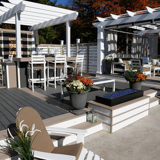 Large beach style courtyard deck photo in Toronto with a pergola