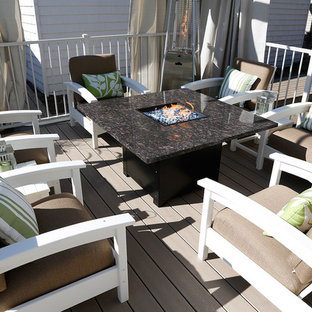 Example of a large beach style courtyard deck design in Toronto with a pergola