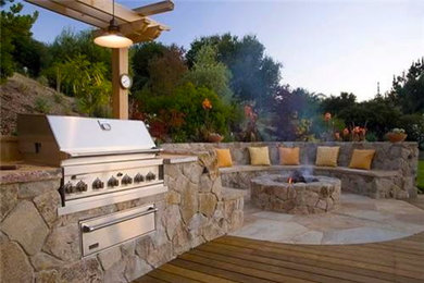 Photo of a large mediterranean back patio in San Diego with an outdoor kitchen and a pergola.