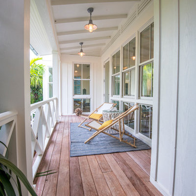 Example of a mid-sized beach style deck design in Tampa with a roof extension