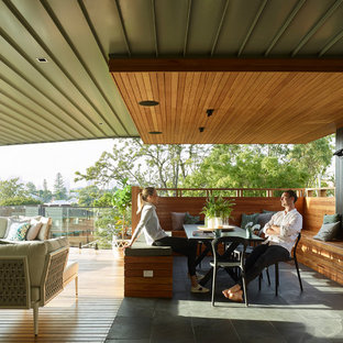 Photo of a contemporary deck in Brisbane with a roof extension.