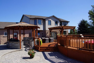 Inspiration for a huge craftsman backyard outdoor kitchen deck remodel in Toronto with a pergola