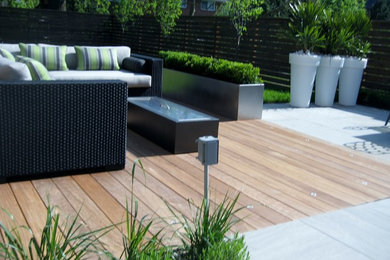 Foto de terraza moderna de tamaño medio sin cubierta en patio trasero con brasero