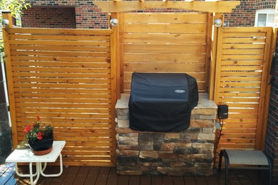 На фото: пергола на террасе среднего размера на заднем дворе в классическом стиле с летней кухней с
