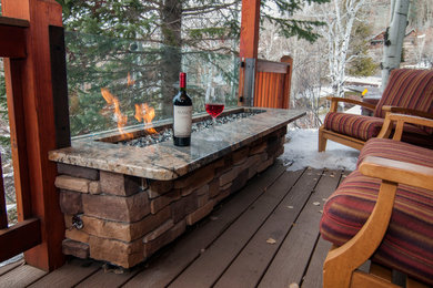 This is an example of a small rustic side terrace in Denver with a fire feature and a roof extension.