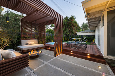 Foto de terraza contemporánea pequeña en patio trasero con brasero y pérgola