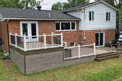 Large minimalist backyard deck photo in Montreal