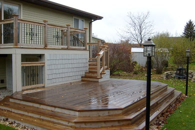 Example of a mid-sized beach style backyard deck design in Milwaukee with no cover