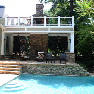 Inspiration for a large timeless backyard deck remodel in Atlanta with a fireplace and a roof extension