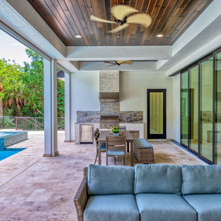 Backyard outdoor kitchen deck photo in Miami with a roof extension